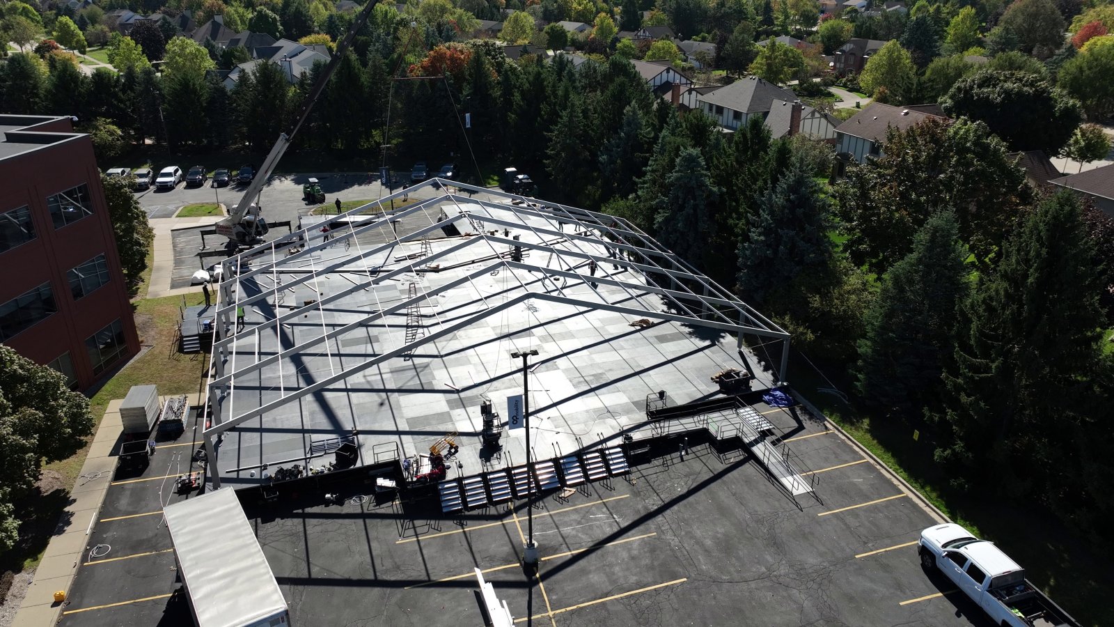 Aerial view of clear-top tent structure being assembled on raised leveled deck