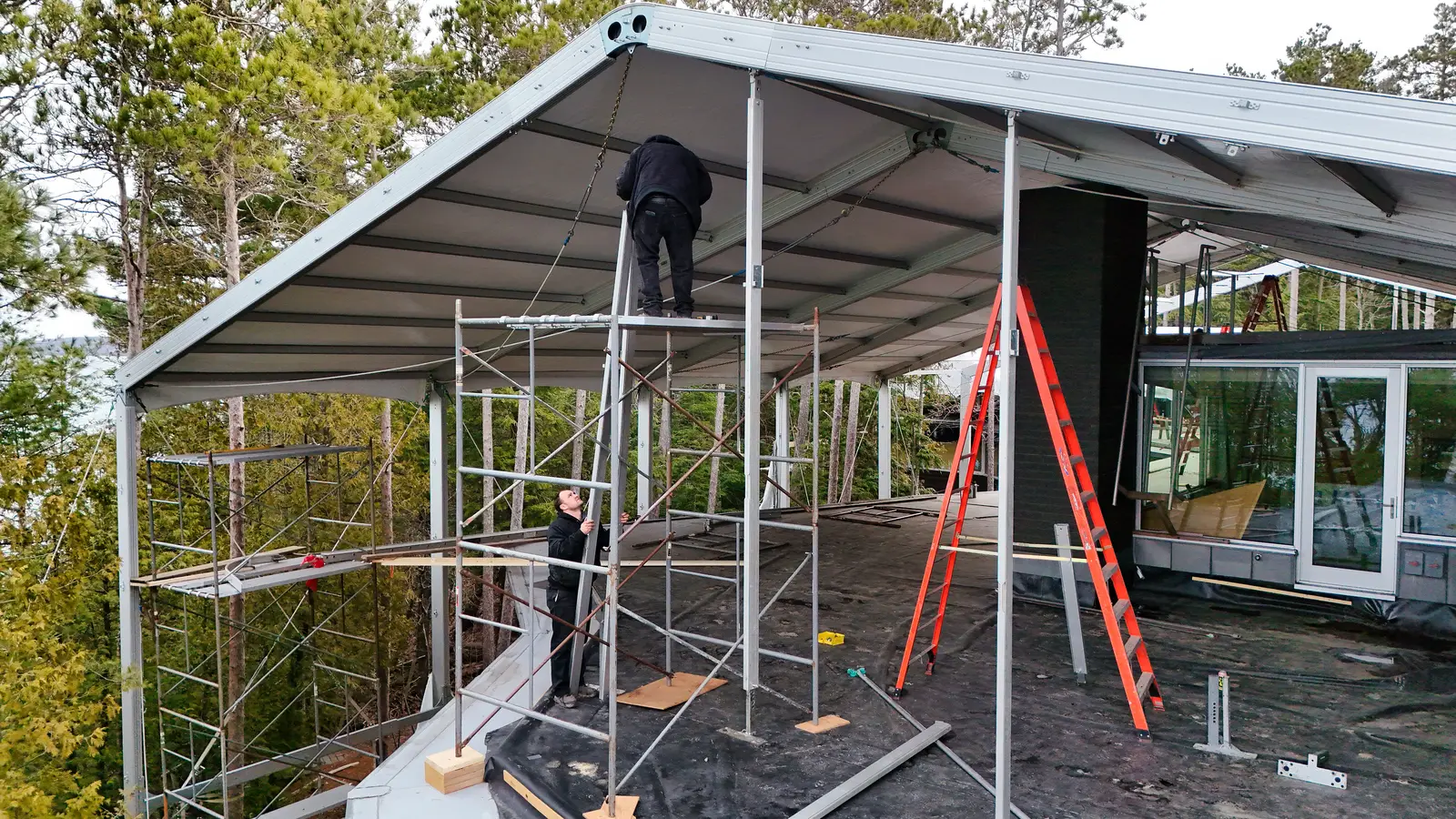 Clearspan structure tent erected over a lakefront house under construction